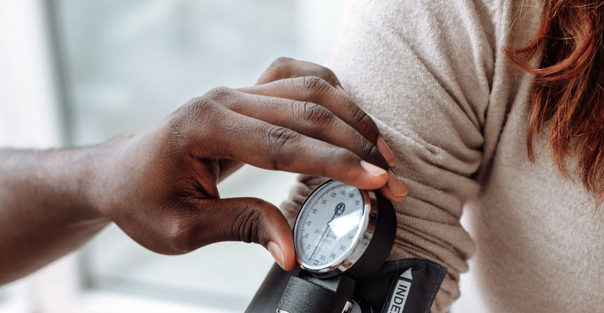 A Person Checking the Blood Pressure of the Patient